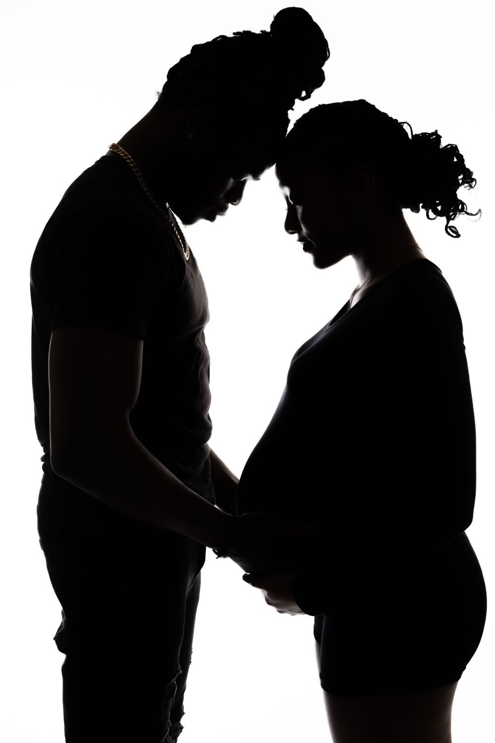 Tender silhouette of a couple sharing a moment during pregnancy photoshoot.