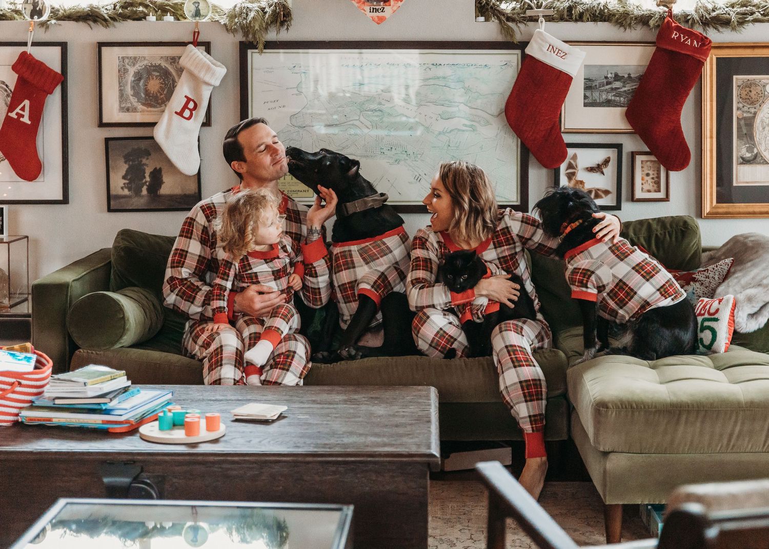 A cozy holiday scene with matching plaid pajamas and Christmas stockings hanging on the wall.