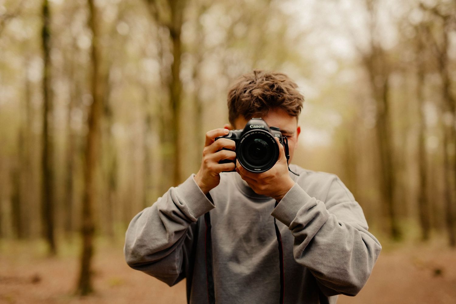 A photographer taking a photo in a warm forest in Chichester