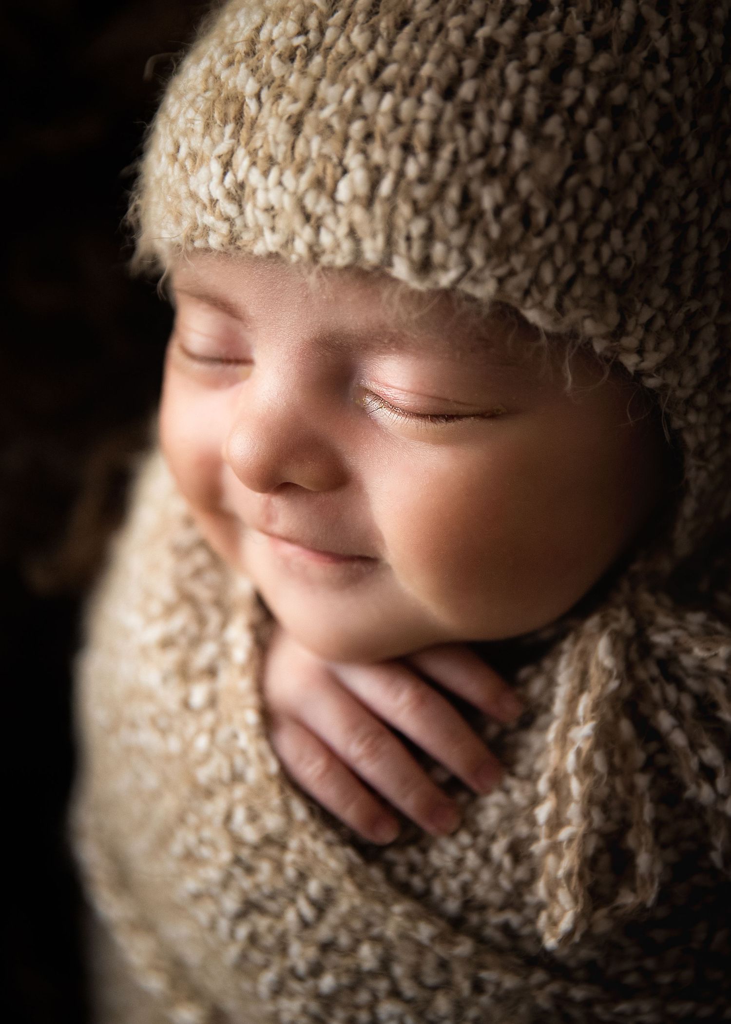 Posed newborn photography with baby swaddled in soft neutral fabrics in Dubai