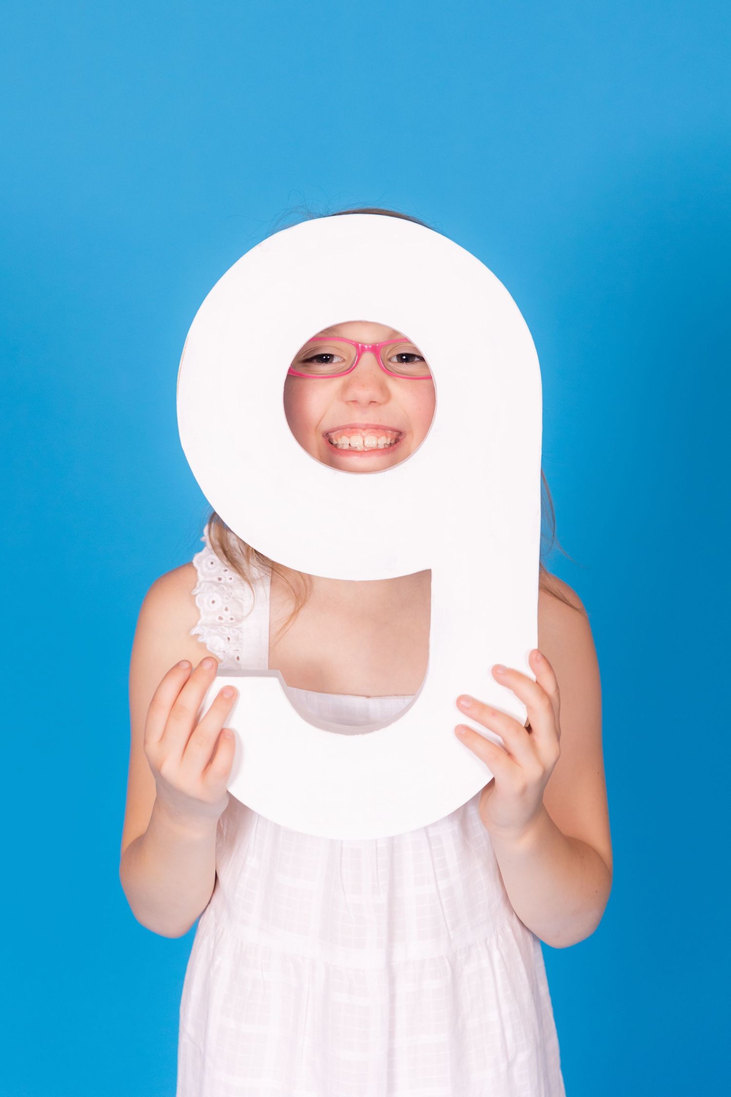 girl looking through large 9 on savage blue jay backdrop in studio clayton new jersey gloucester county