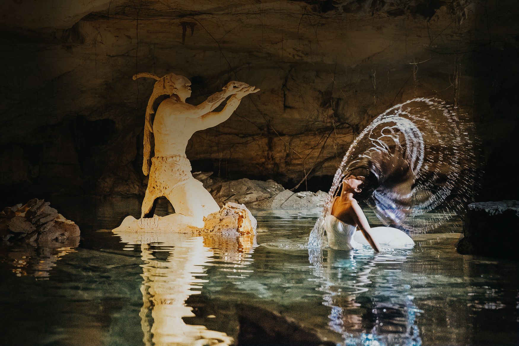 A dramatic underwater cave scene with light beams and bubbles creating ethereal reflections.