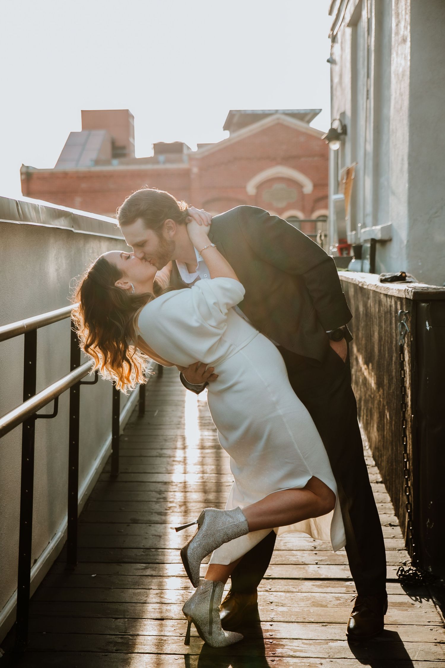 A full body photo of a couple sharing a kiss at The Vendue