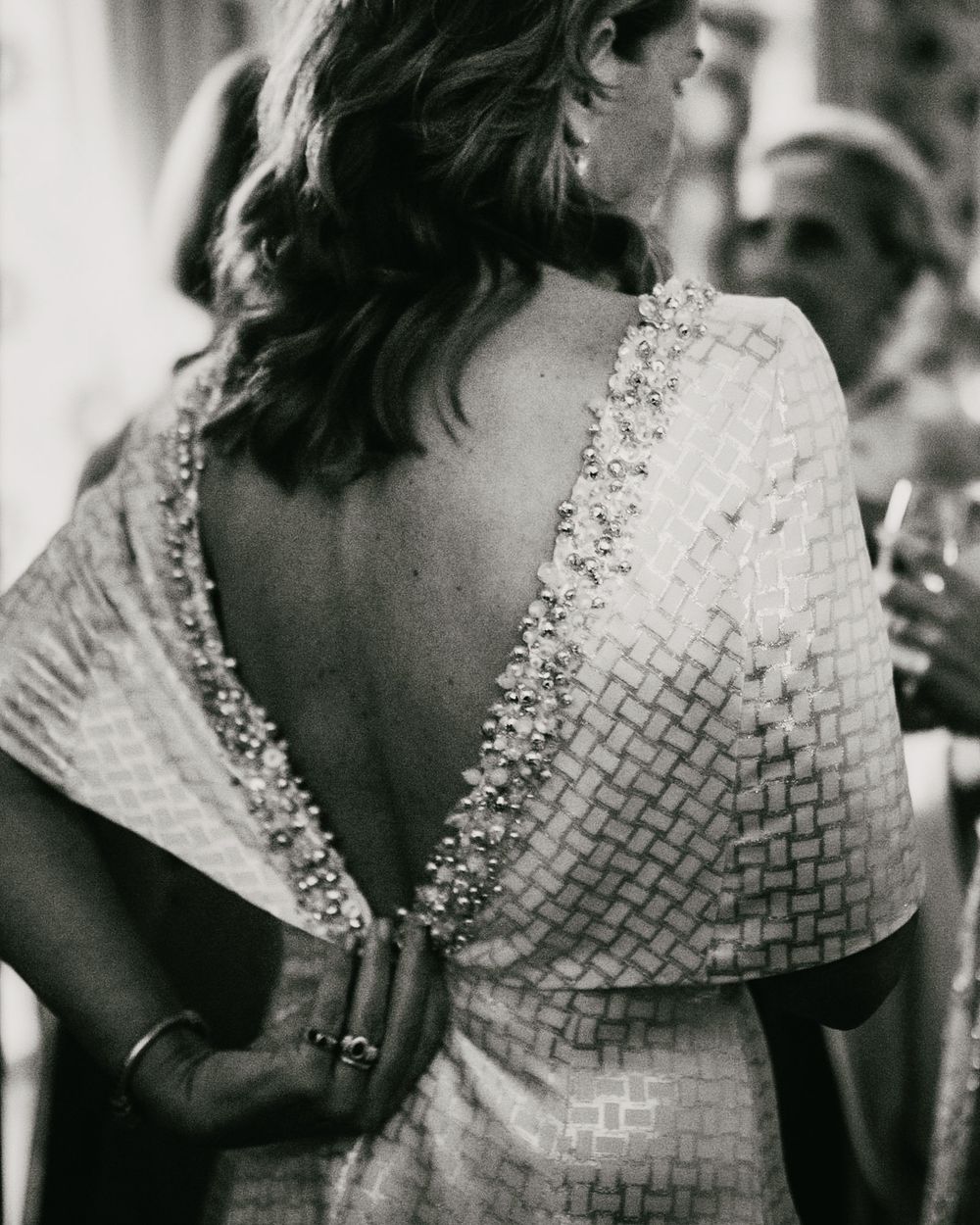 Detailed back view of an intricate woven dress with beaded embellishments.
