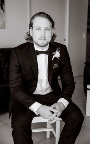 Formal portrait of groom in classic black tuxedo and bowtie.