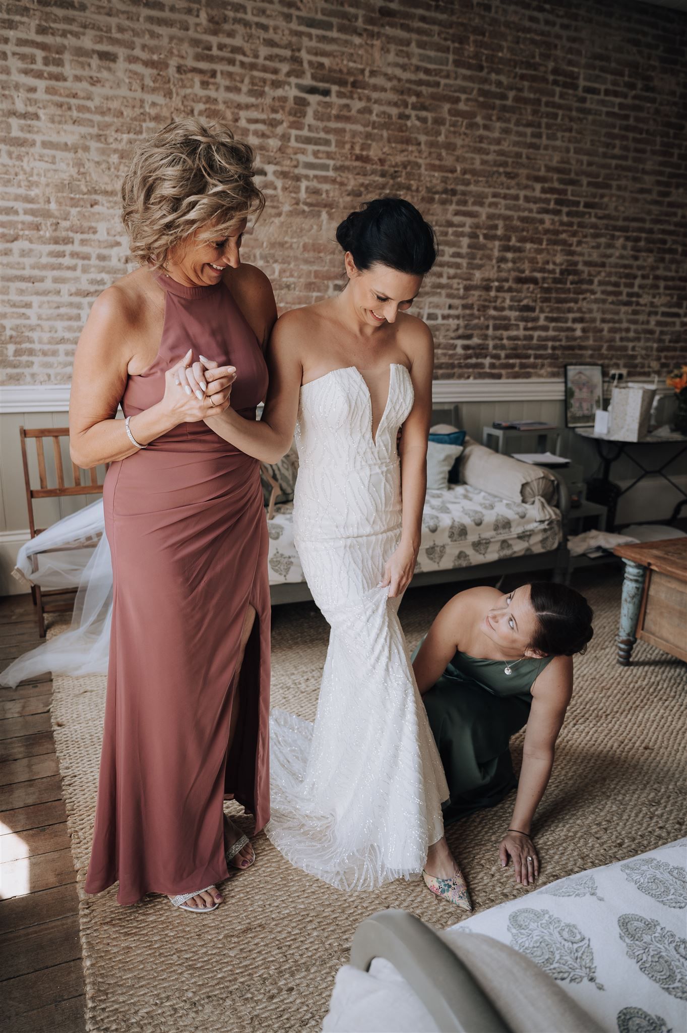 Wedding dress fitting session in rustic room with exposed brick walls.