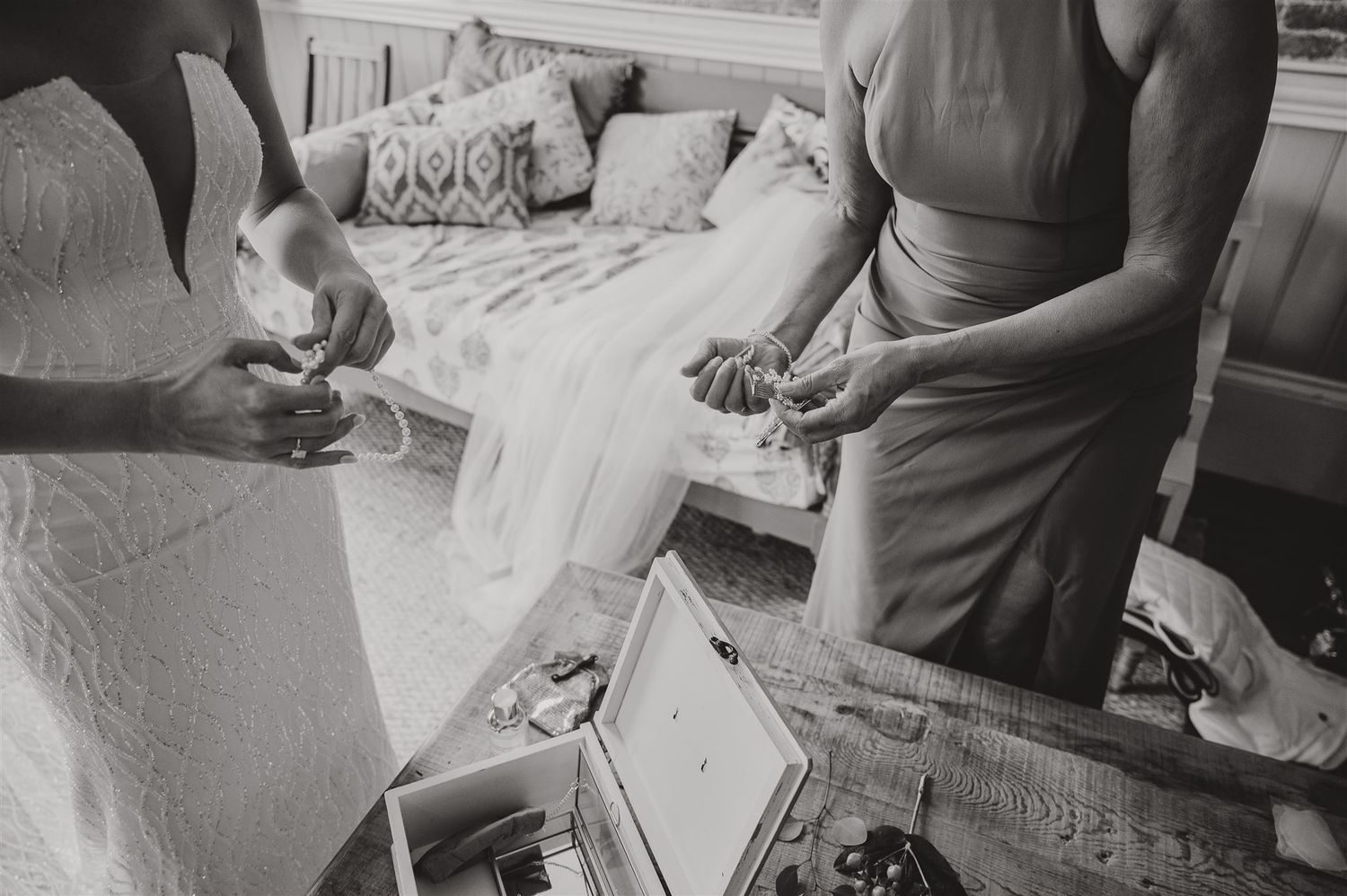 Black and white photo of wedding preparations with dress and accessories.