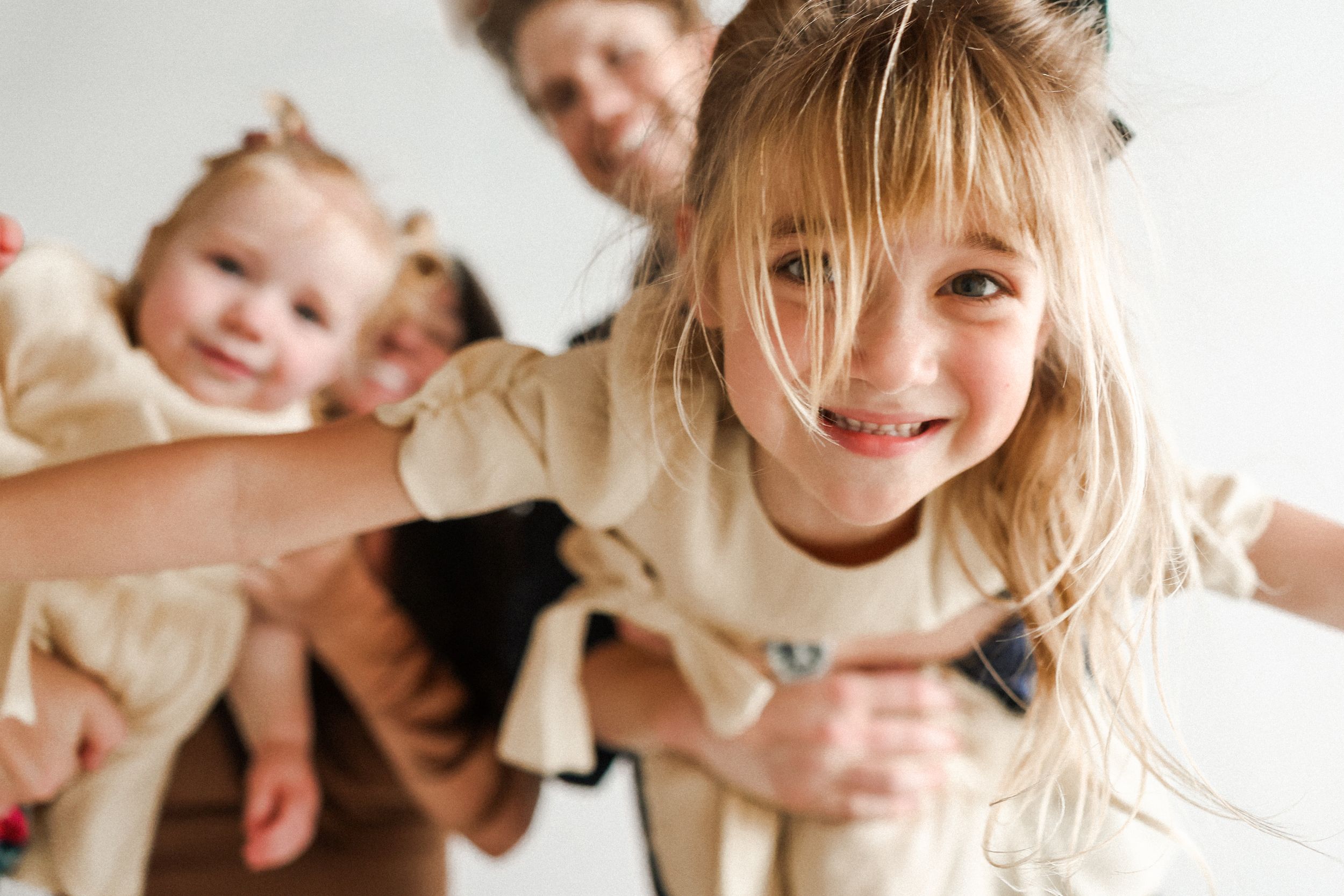 Natural light portrait of joyful family moments against white background.