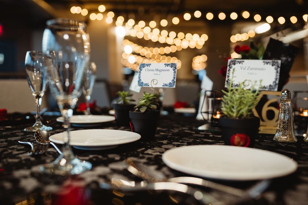 Elegant table setting with string lights and place settings for a formal event.