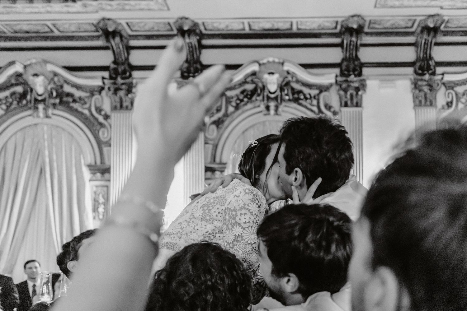 Elegant wedding reception venue decorated with ornate chandeliers and white draping.