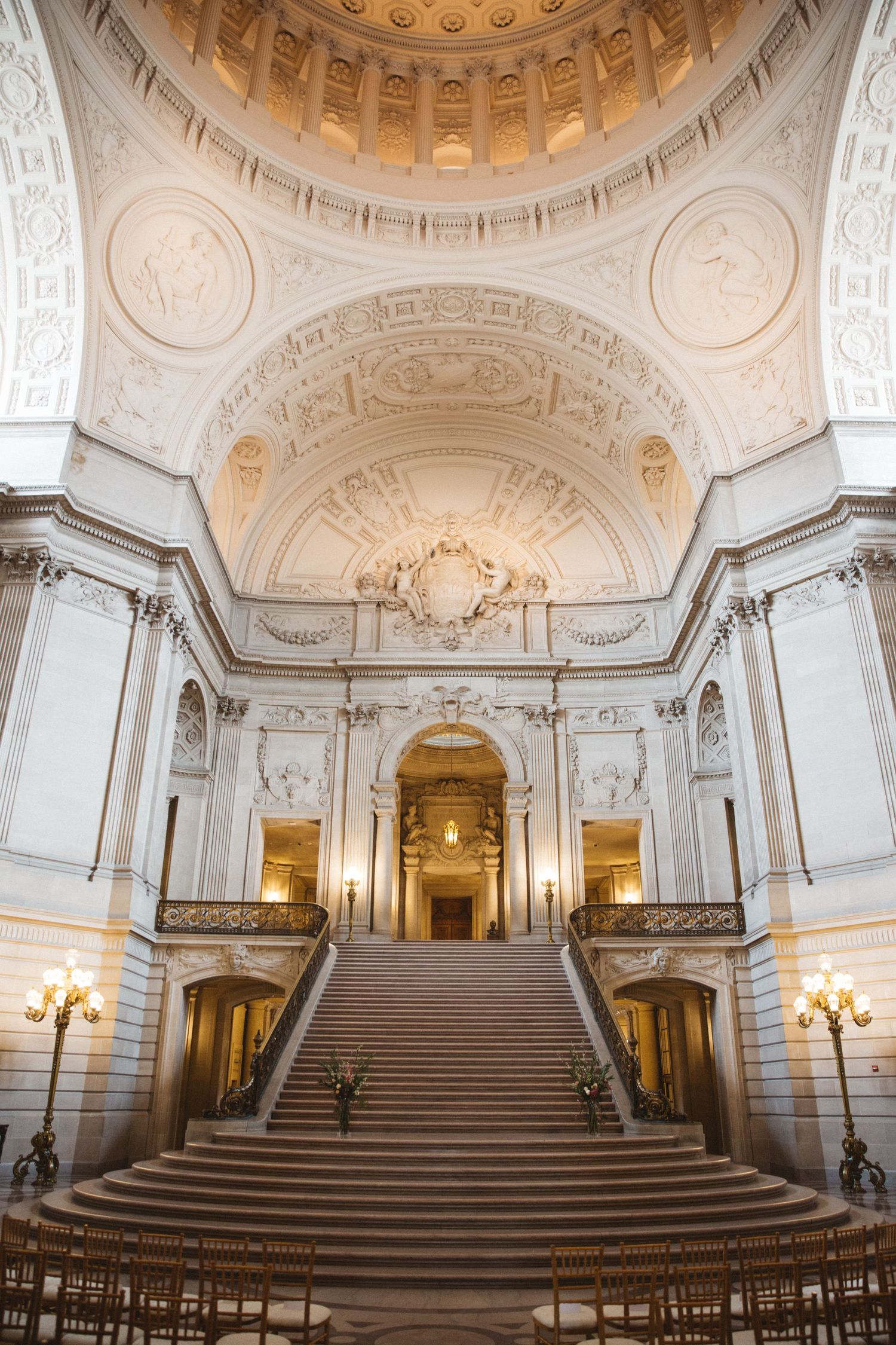 Majestic white marble staircase with ornate domed ceiling and classical architectural details.