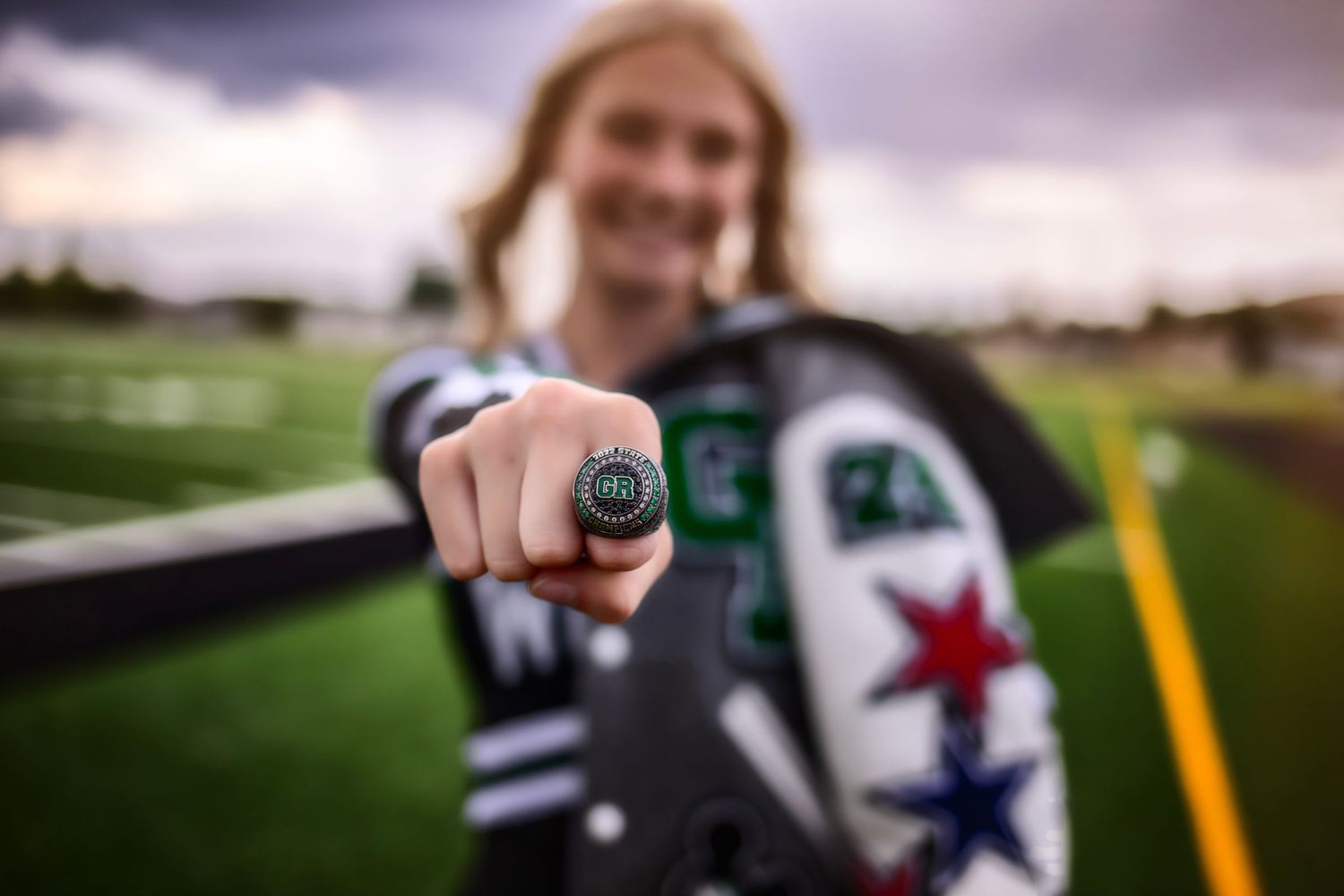 A ring is shown in sharp focus against a blurred sports field background.