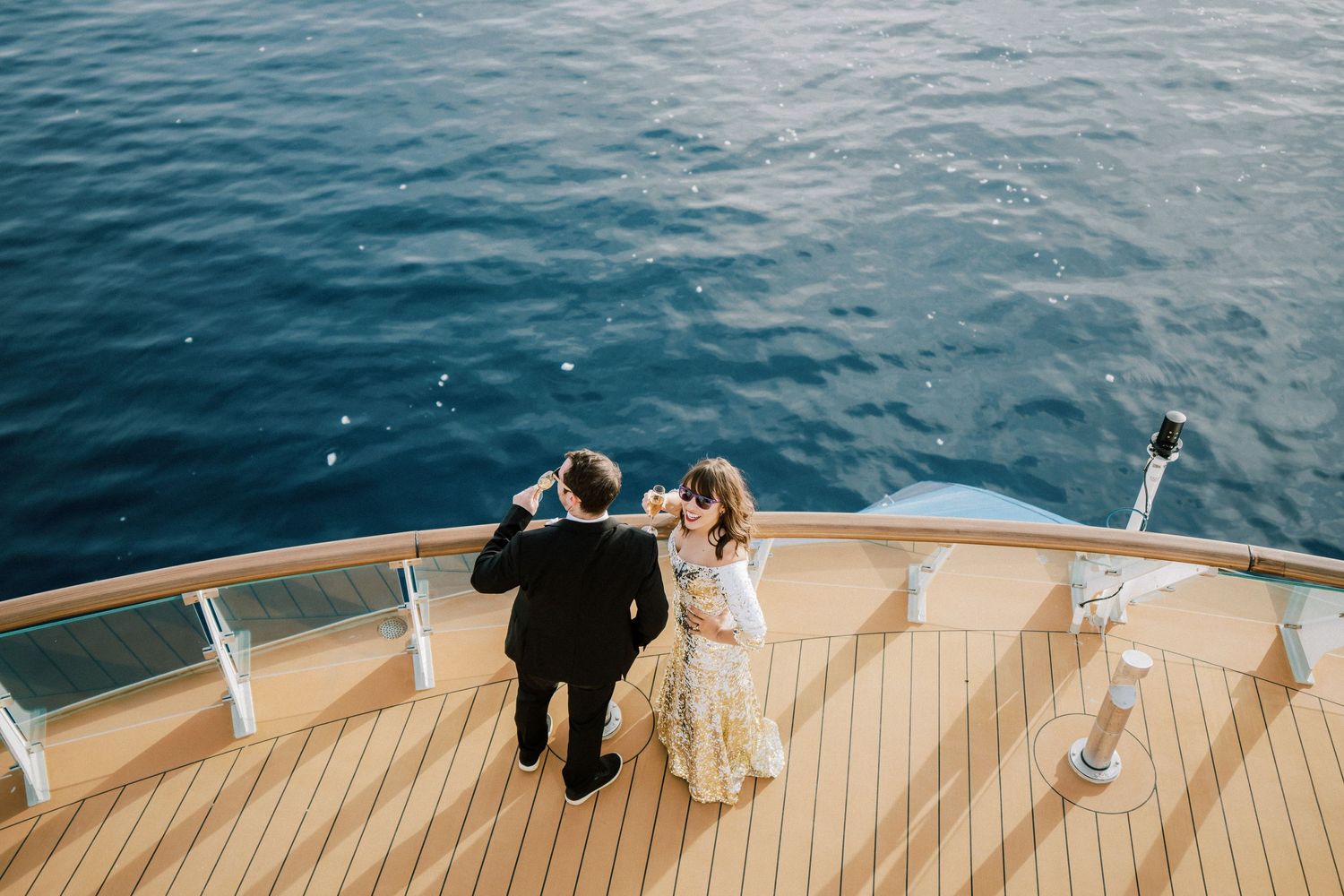 A couple enjoying a romantic moment on the bow of a ship surrounded by Antarctic scenery.