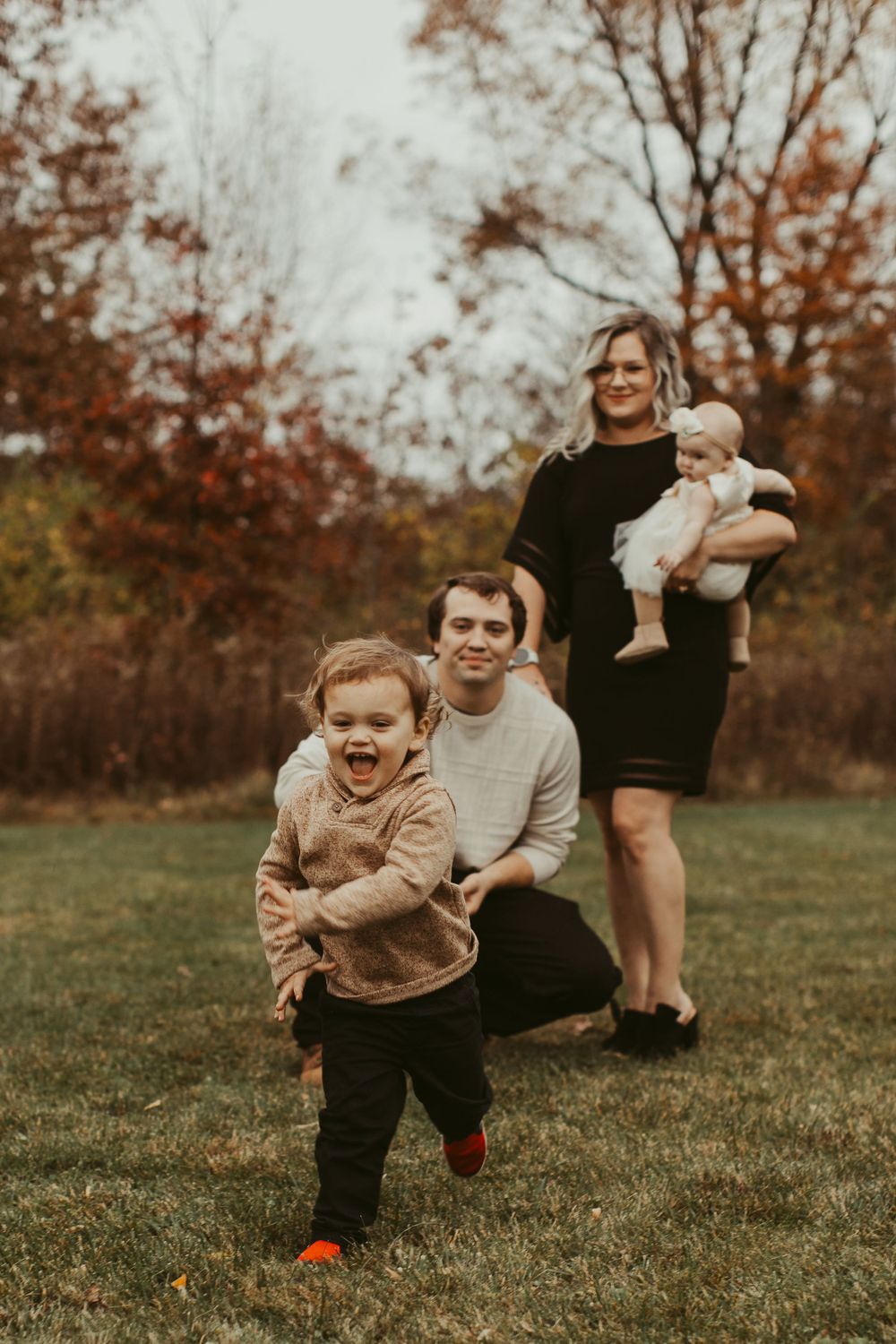 A playful group enjoying a fun moment together on grassy ground during fall.