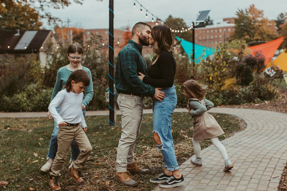 People walking together on a brick pathway surrounded by fall foliage.