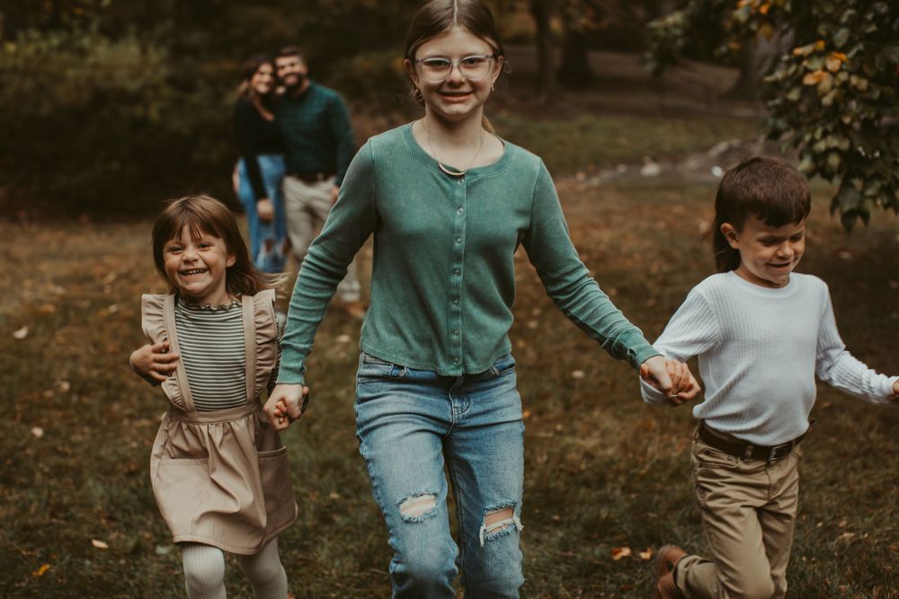 People walking together through a park with autumn trees in the background.
