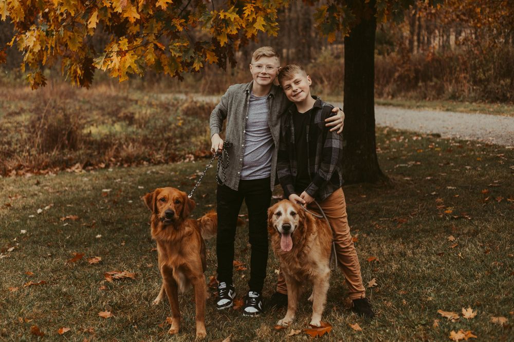 Casual outdoor family portraits with pets among autumn foliage.