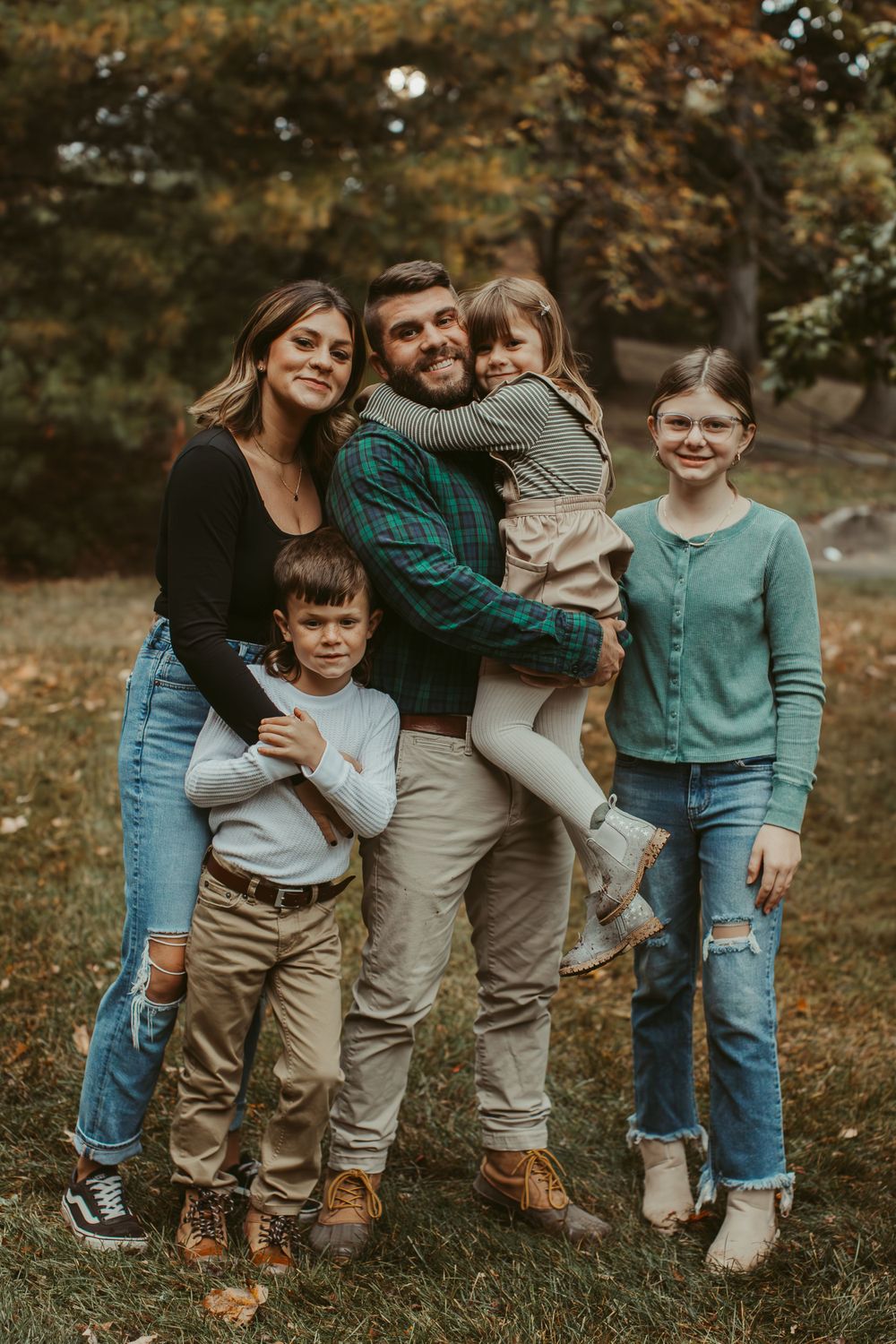 A casual group photo of people wearing coordinated blue and neutral outfits in an autumn setting.