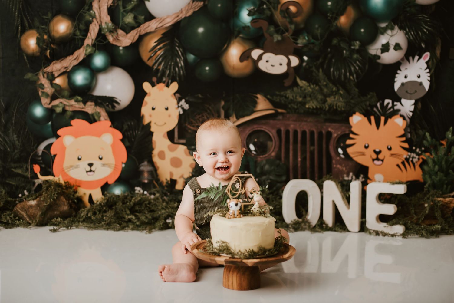 Baby's first birthday celebration with safari animal decorations and smash cake.