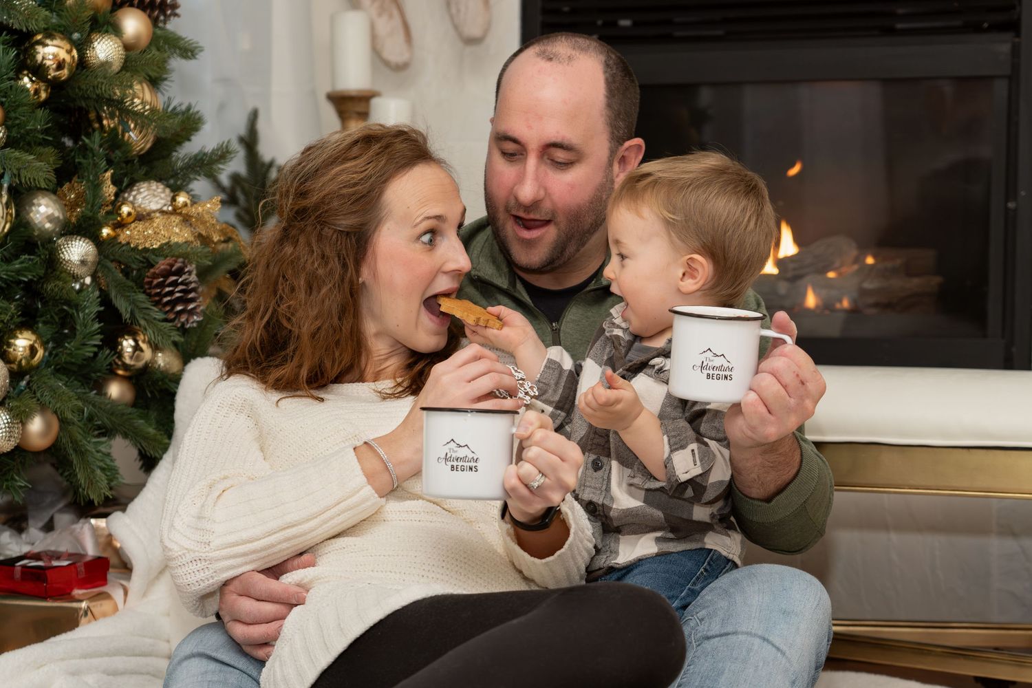 A cozy family enjoys holiday cookies and hot drinks by a decorated Christmas tree in their living room.