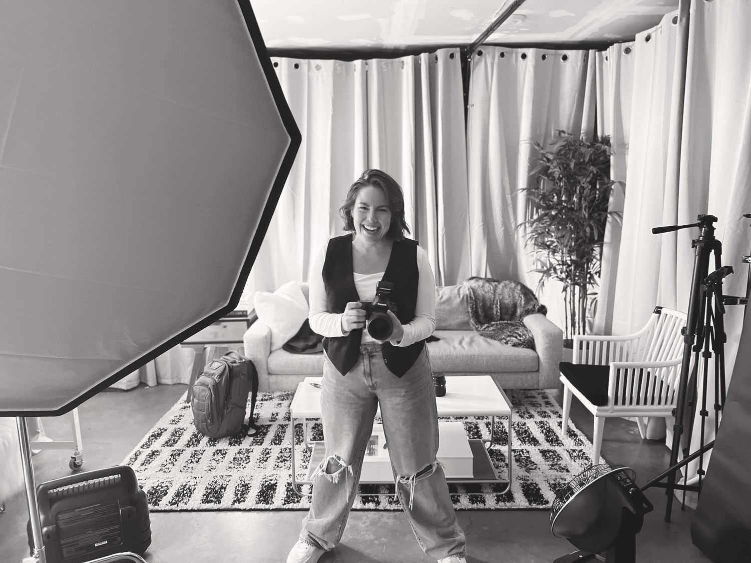 Black and white photo of a photography studio setup with lighting equipment and backdrop.