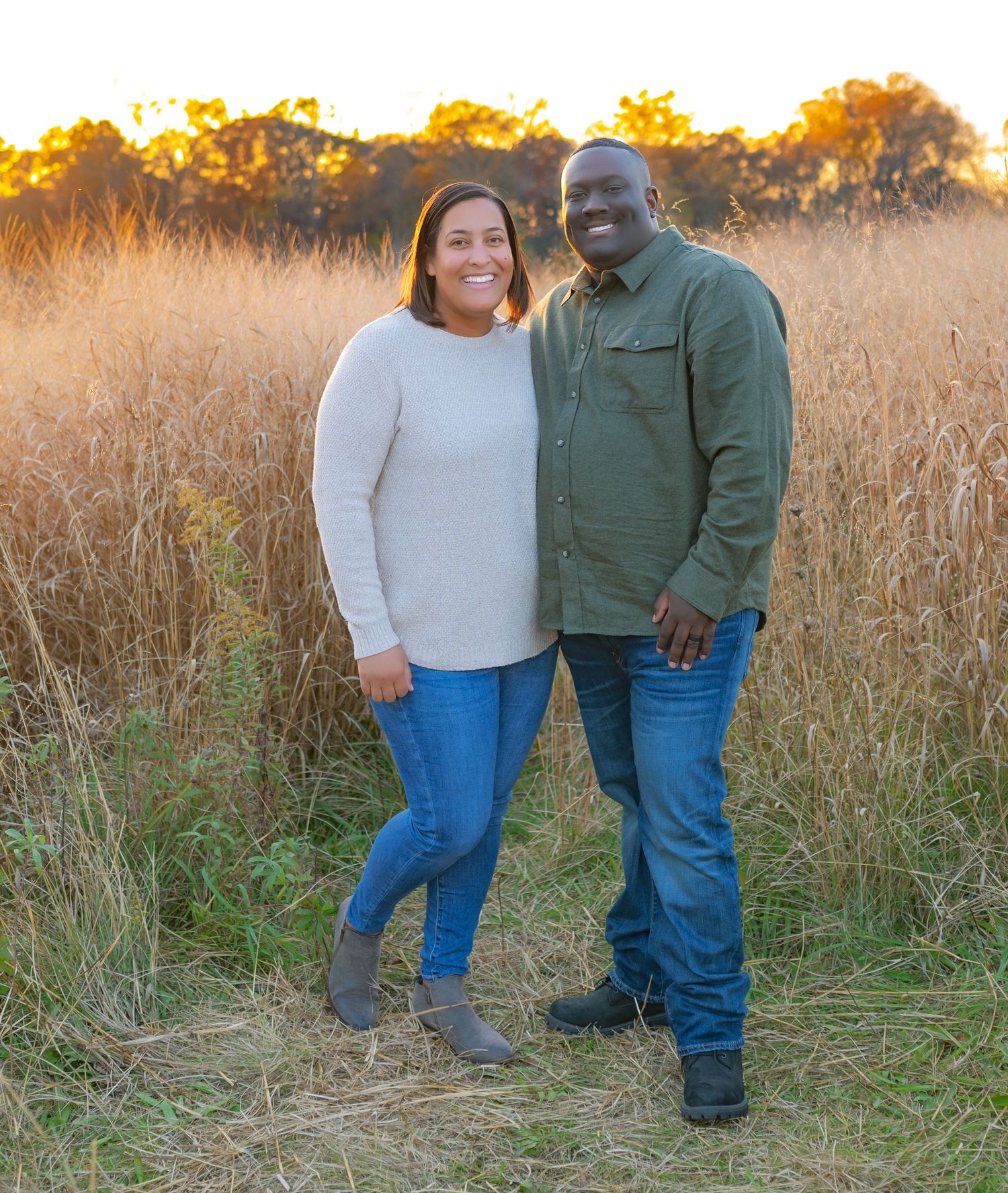 Couple standing in a field of tall golden grass at golden hour. Wrightstown NJ Family Photographer