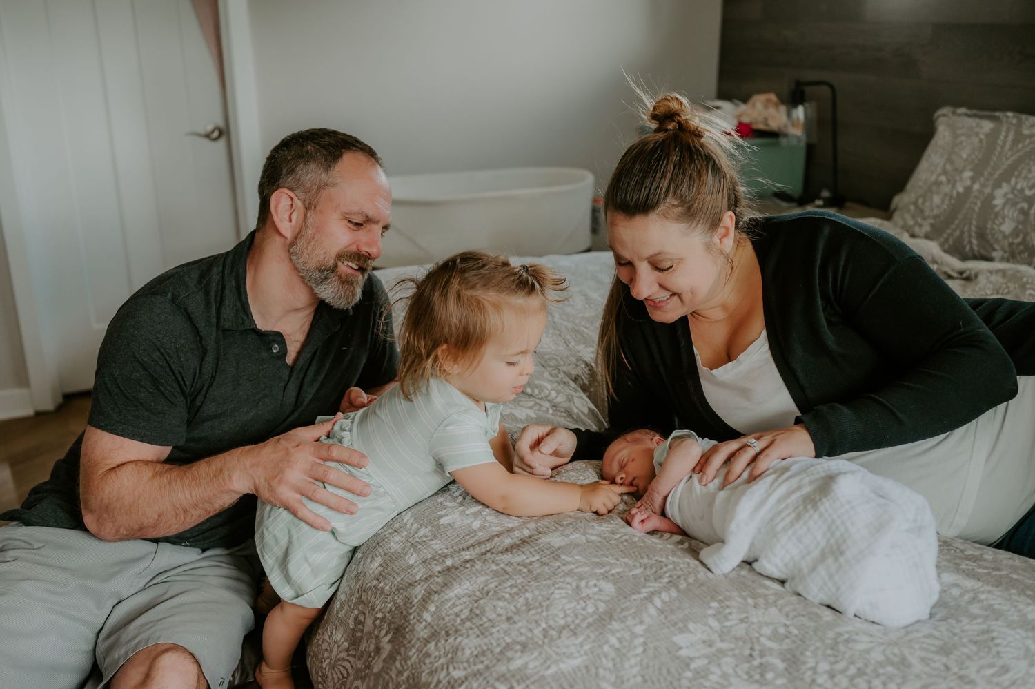 Family lays beside newborn baby