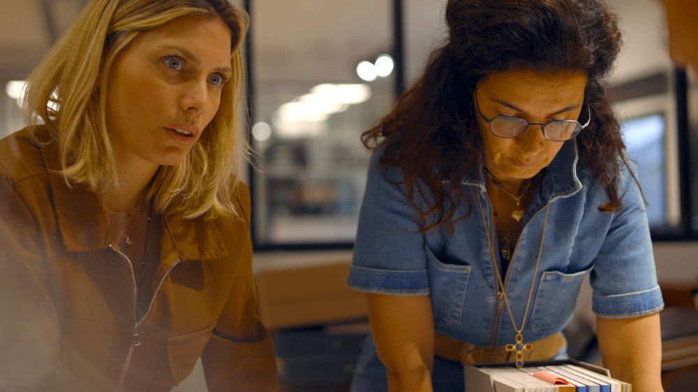 Two people reviewing documents together at a workspace.