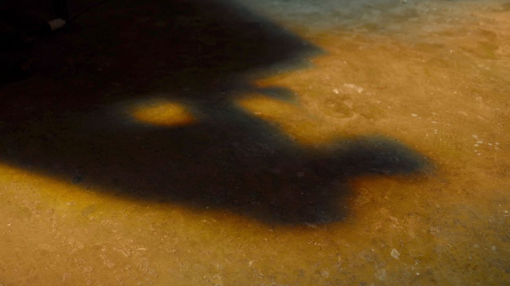 Golden textured surface with dramatic dark shadows creating contrast.