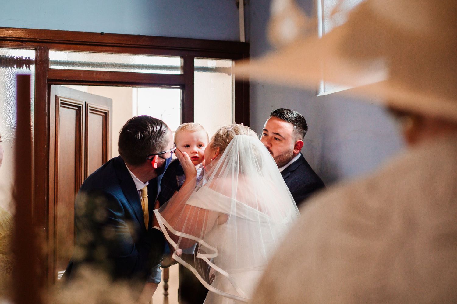 Interior wedding ceremony shots captured through doorways and windows.