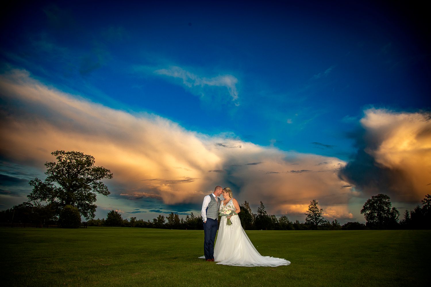 bride and groom against cloudy sunset whitlebury park wedding photography Northamptonshire