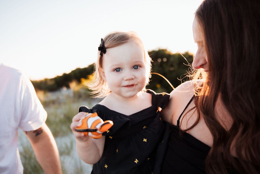 Candid sunset moment on the beach showing a close interaction and black polka dot dress. third beach middletown rhode island