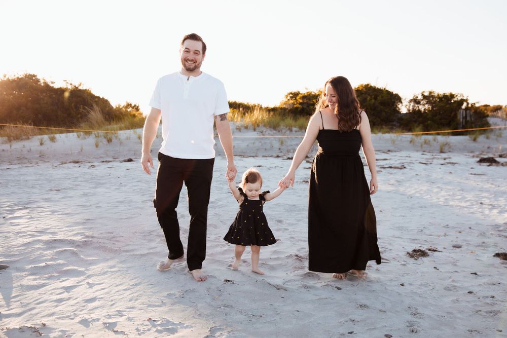 Family walking together hand in hand on white sandy beach at sunset. third beach middletown rhode island