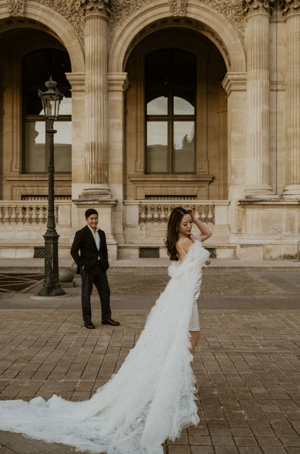 Elegant wedding photography session with couple posing against ornate classical architecture.
