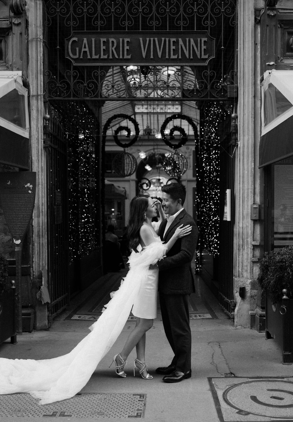 A black and white wedding portrait at the entrance of Galerie Vivienne in Paris.