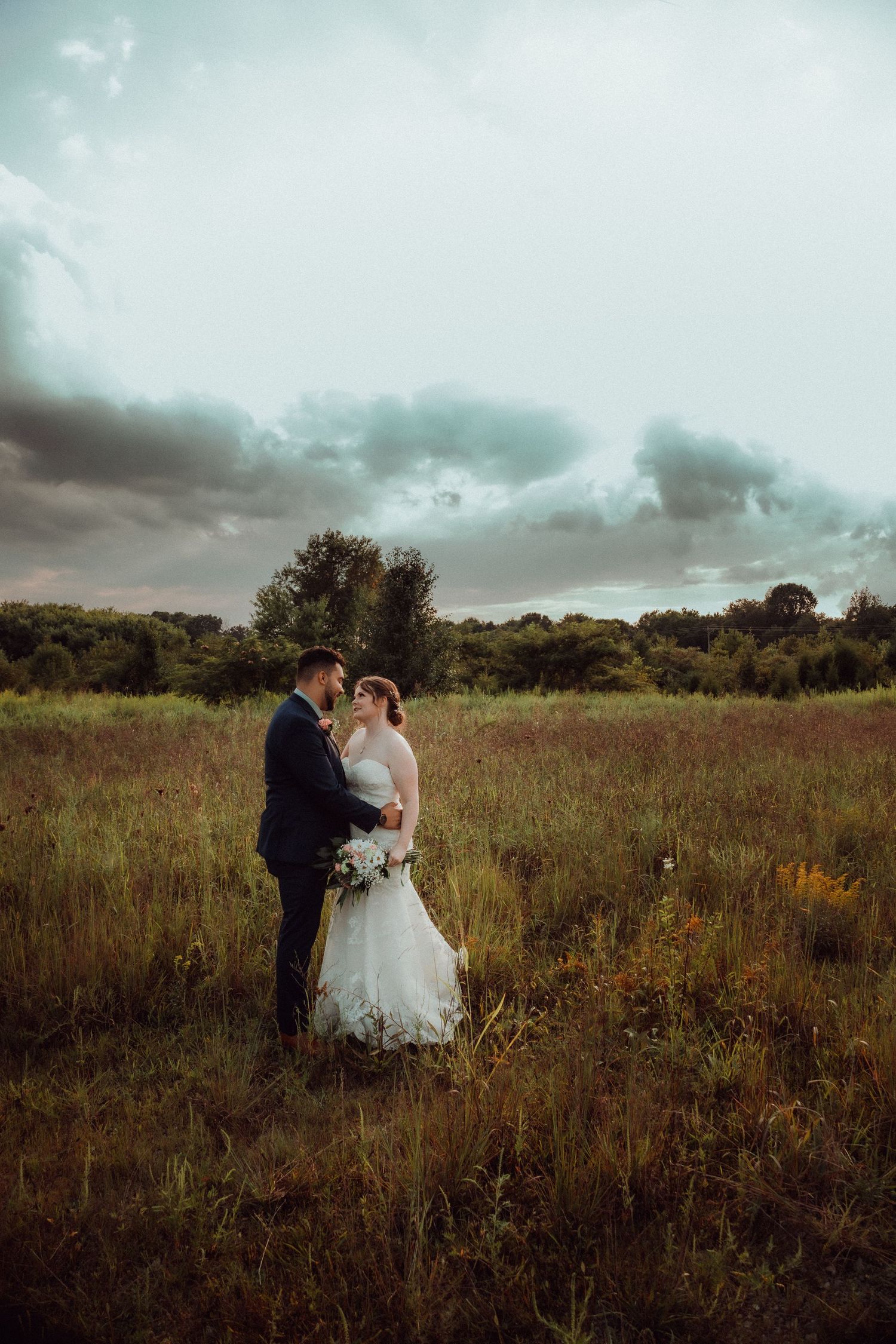 Louisville wedding photographer, Jenna and Cody Lehman, standing in a field