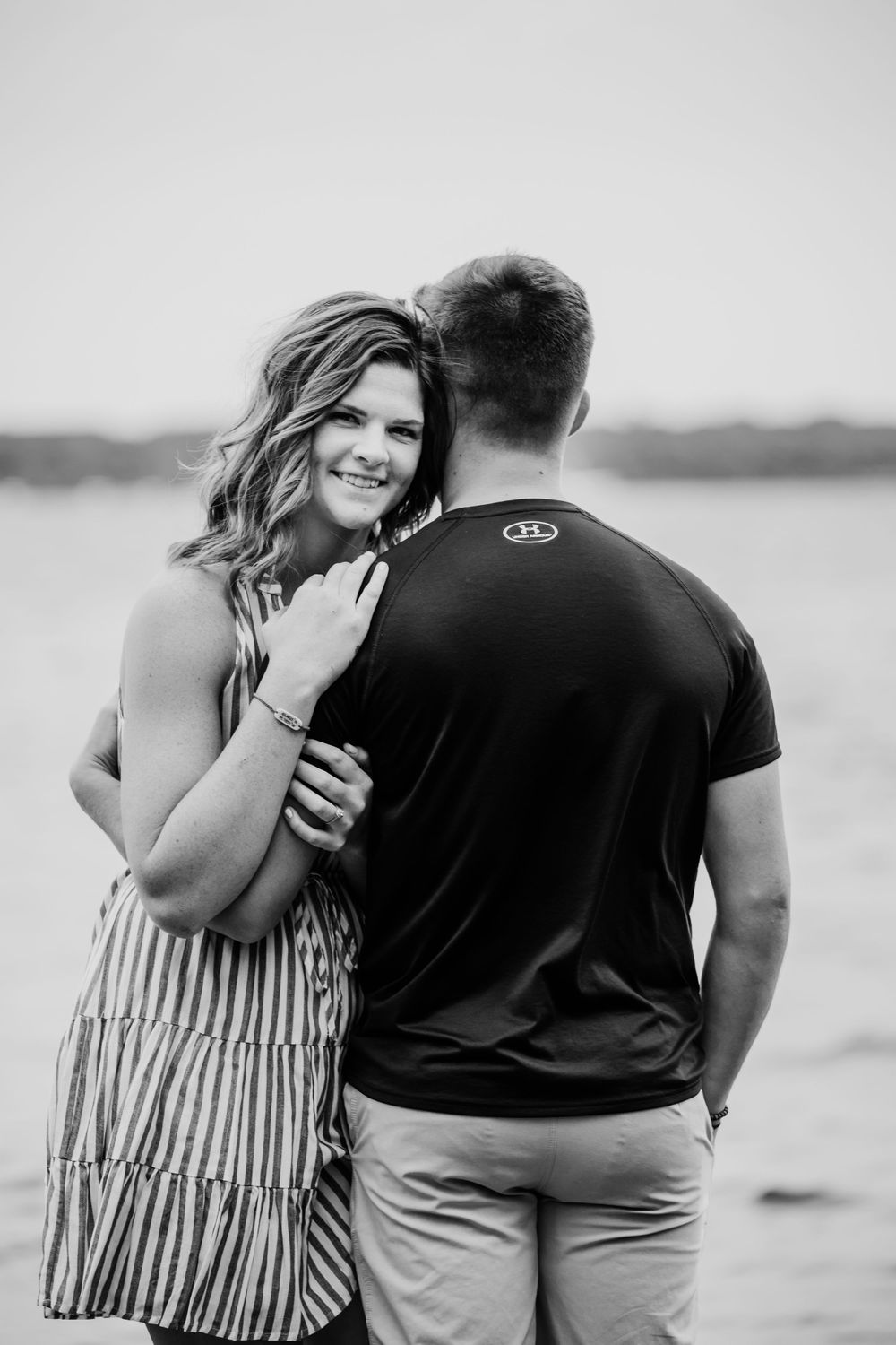 Couple embracing during an outdoor engagement photoshoot in black and white.