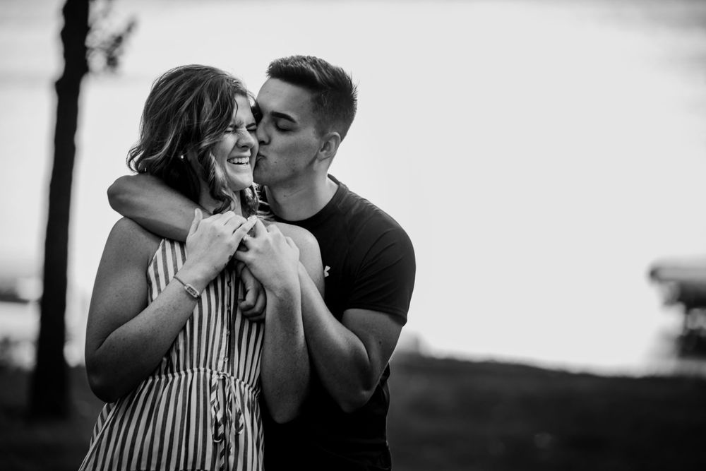 Intimate black and white portrait of couple sharing a romantic moment outdoors.
