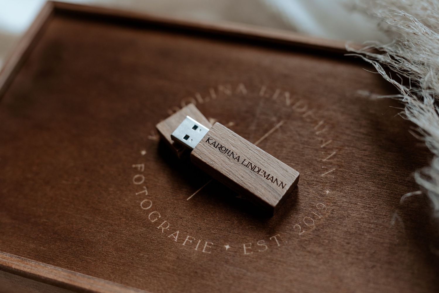 Close-up of a wooden USB drive with custom engraving.