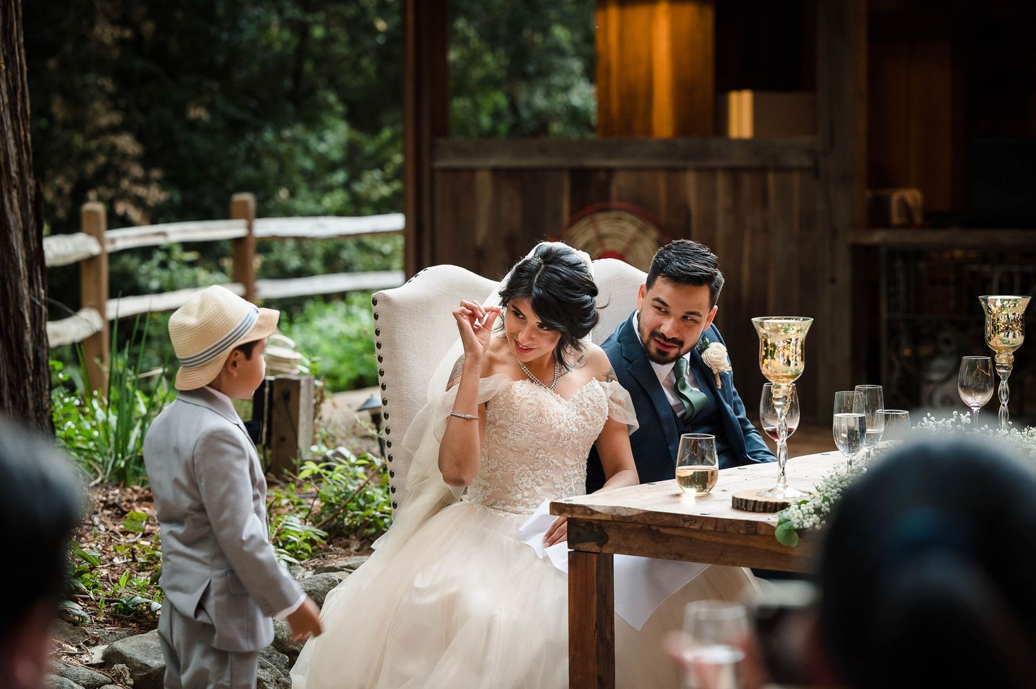 A reception scene at a rustic wooden venue with decorated dining tables and festive lighting.