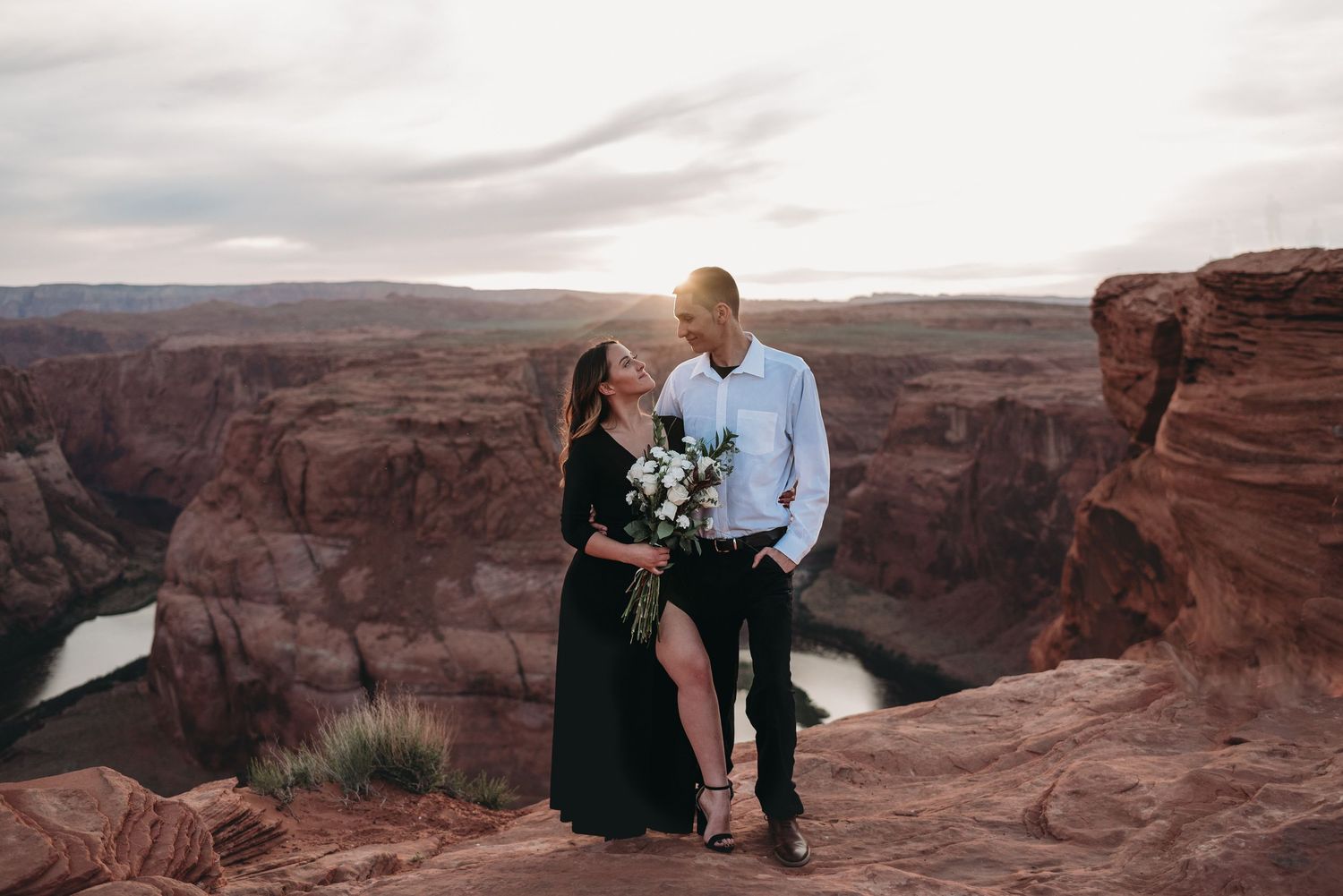 Scenic overlook of vast desert canyons with red rock formations at sunset.