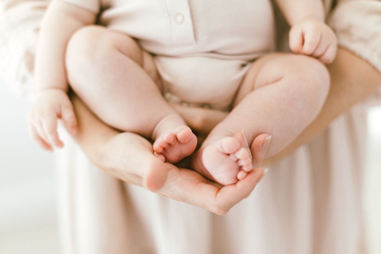 Detail shots of baby's hands and clothing in gentle natural light.