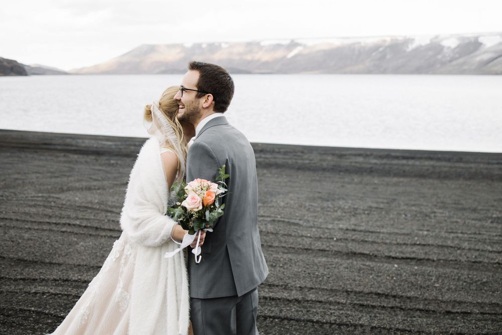 Romantic wedding portrait against snowy mountain backdrop and lake.