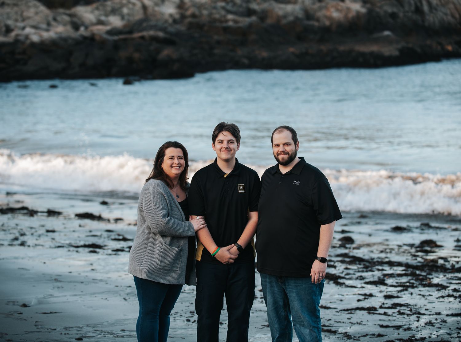 A group enjoying a fun day at a rocky beach during sunset.