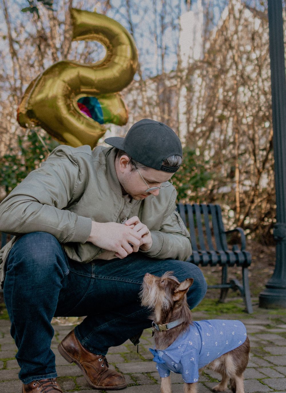 pet portrait man and small dog in blue shirt with large gold balloon