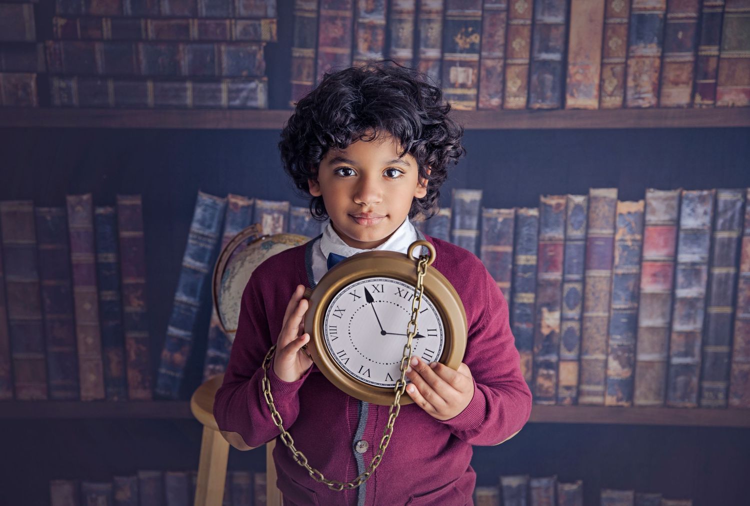 8 year old boy holding a large pocket watch handsome child