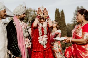 Traditional Indian wedding ceremony with guests participating in cultural rituals outdoors.
