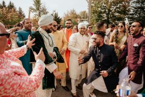 Festive outdoor celebration with guests in colorful traditional attire dancing together.