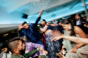 Lively dance celebration with guests jumping and celebrating at a wedding reception.