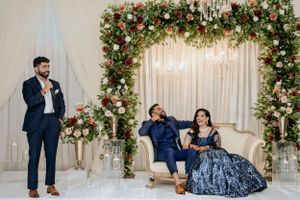 Wedding scene with elegantly decorated floral arch and seating arrangement.